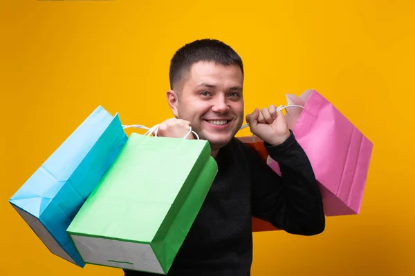 Foto del hombre con bolsas de compras multicolores — Foto de Stock