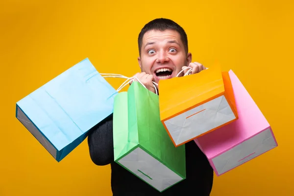 Imagem do homem com sacos de compras no fundo laranja — Fotografia de Stock