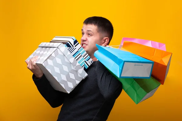 Photo of male shopper with paper bags and boxes