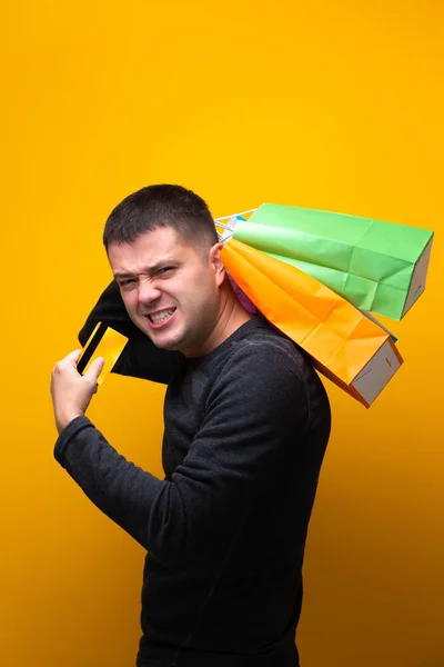 Foto do homem com cartão bancário e sacos de compras multicoloridos — Fotografia de Stock