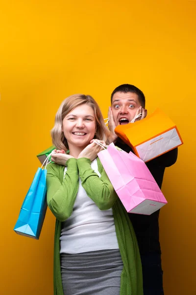 Gritando homem e mulher com sacos de compras — Fotografia de Stock