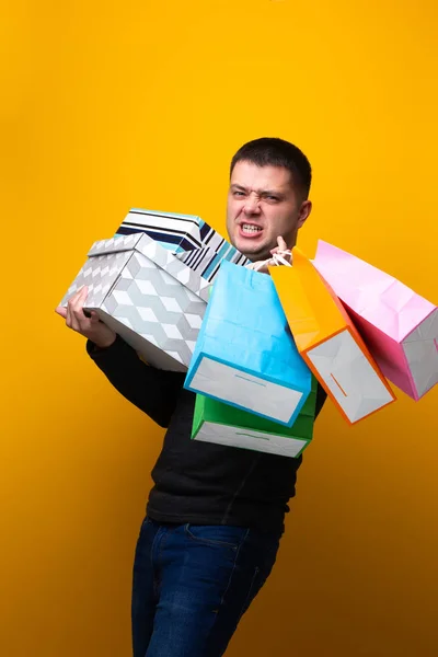 Photo of male shopper with paper bags and boxes