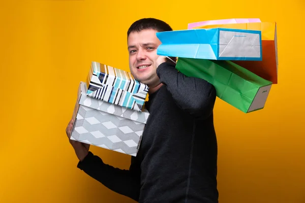 Photo of happy male shopper with paper bags and boxes
