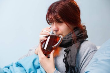 Yatakta oturmuş çay hasta esmer olan resmi .