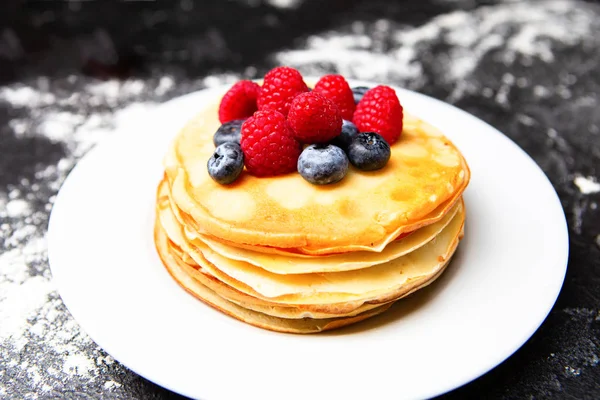 Image of plate with pancakes, blueberries, raspberries dusted with icing sugar. — Stock Photo, Image
