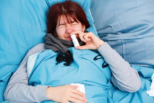 ベッドに横になっている点鼻薬を使用して病気の女性の写真 — ストック写真