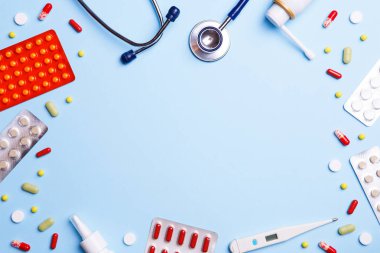 Soğuk algınlığı ilacı, termometre ve mavi bir arka plan üzerinde phonendoscope.