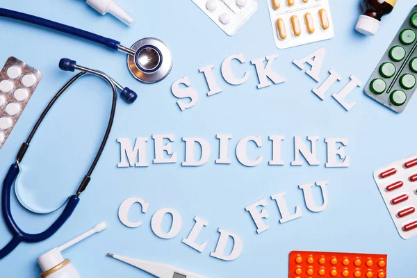 Cold medicine, thermometer, phonendoscope and words: sick, ail, medicine, cold and flu