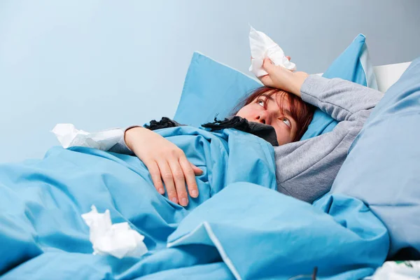 Foto de mujer enferma con pañuelos de papel acostada en la cama —  Fotos de Stock