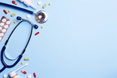 Soğuk algınlığı ilacı ve mavi bir arka plan üzerinde phonendoscope.
