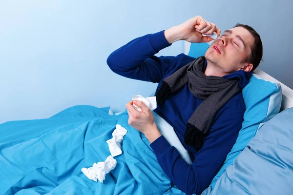 Bruna malato maschio utilizzando spray nasale mentre sdraiato a letto  . — Foto Stock
