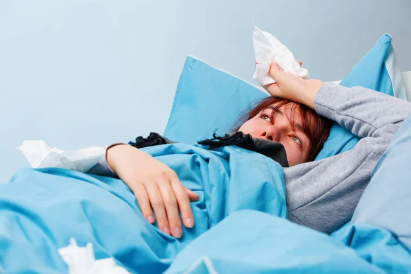 Photo of sick woman with paper handkerchiefs lying on bed — Stock Photo, Image