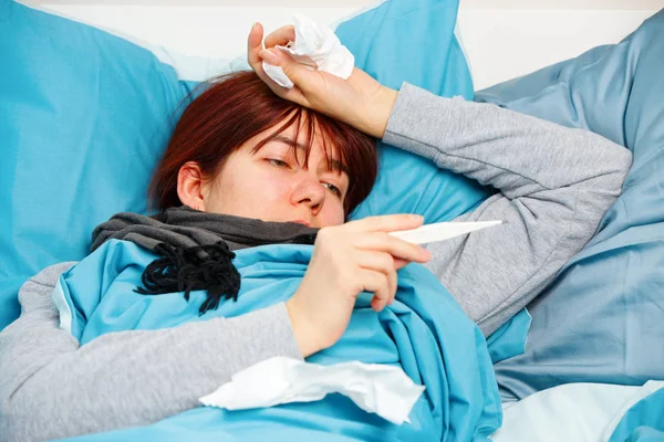 Foto di donna malata con termometro sdraiata sul letto . — Foto Stock