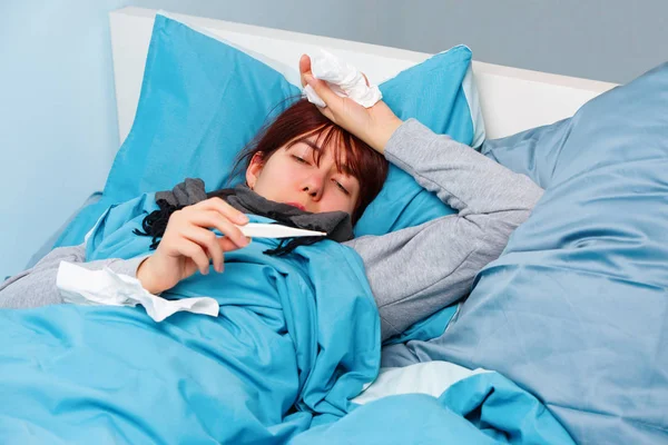 Foto de mulher doente com termômetro deitado na cama . — Fotografia de Stock