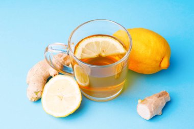 Mavi arka planda çay, limon ve zencefil