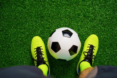 Yeşil çim üzerinde futbol ayakkabıları ve futbol