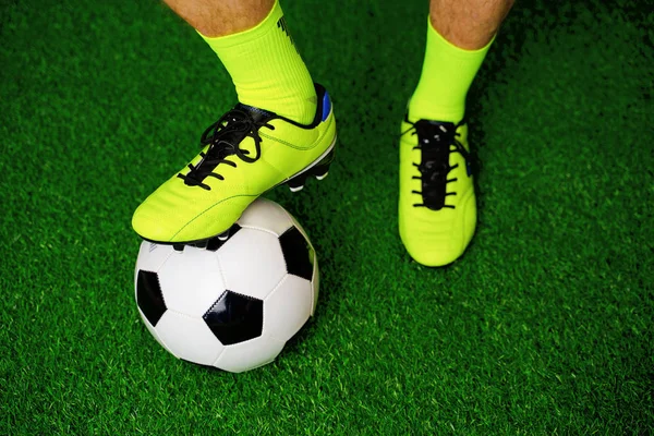 Yeşil çim üzerinde futbol ayakkabıları ve futbol — Stok fotoğraf