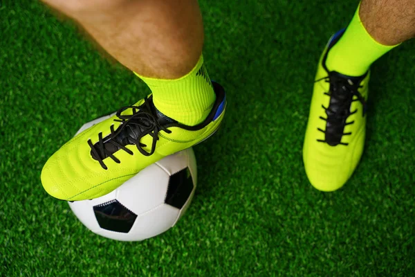 Soccer shoes and football on the green grass — Stock Photo, Image