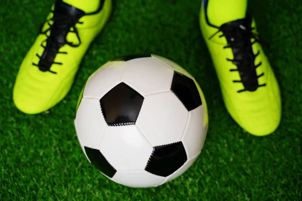 Fotbolls skor och boll på det gröna gräset — Stockfoto