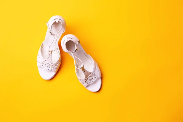 Whithe sandals with high heel on yellow background. — Stock Photo, Image