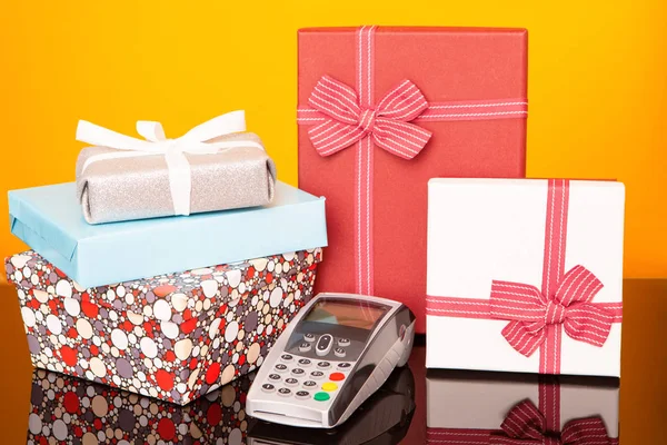 Terminal, boxes with gifts on black glass table and yellow background.