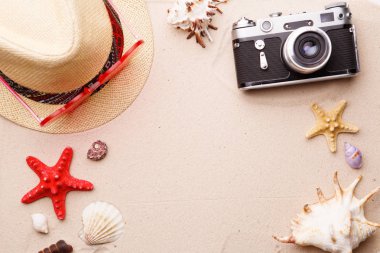 Plaj aksesuarları - güneş gözlüğü, şapka ve kum witn kabukları ve seastar kamera.