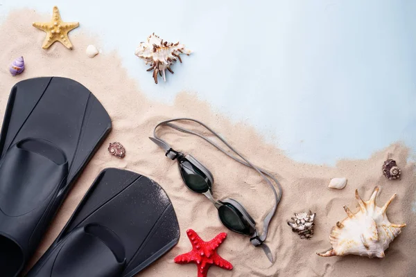 Gafas de natación y aletas en la arena con conchas y estrellas de mar . — Foto de Stock