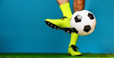 Yeşil çim üzerinde top ile futbol oyuncusu.