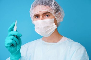 Steril mavi üniformalı cerrah, tıbbi eldiven ve maske