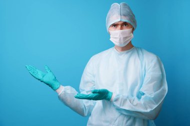 Steril mavi üniformalı cerrah, tıbbi eldiven ve maske