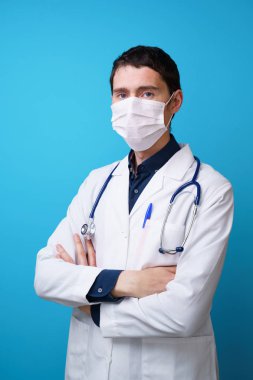 Boynunda stetoskop ve yüzünde maske olan bir doktorun portresi.