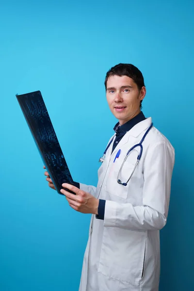 Retrato de um médico com um estetoscópio no pescoço e um raio-X na mão — Fotografia de Stock