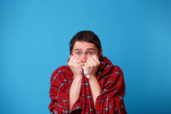 Больной человек, завернутый в одеяло, держит белый платок
.