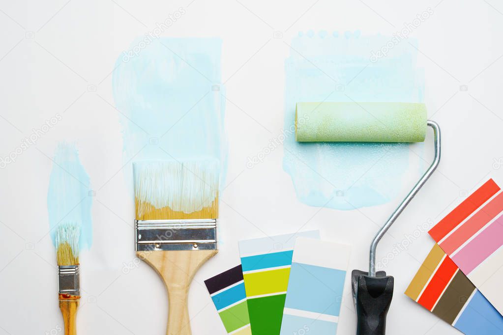 Picture of palette with blue and green colors, roller, brushes