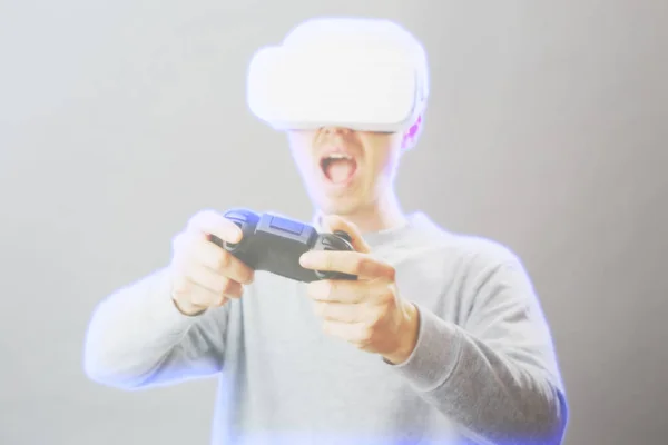 Homem com fone de ouvido realidade virtual está jogando jogo. Imagem com efeito holográfico . — Fotografia de Stock