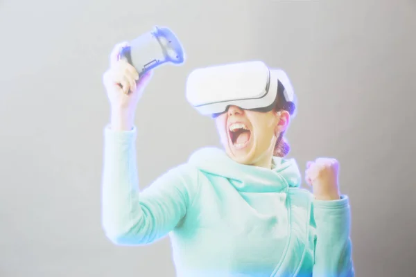 Mulher com fone de ouvido realidade virtual está jogando jogo. Imagem com efeito holográfico . — Fotografia de Stock