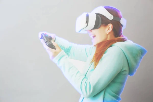 Mulher com fone de ouvido realidade virtual está jogando jogo. Imagem com efeito holográfico . — Fotografia de Stock