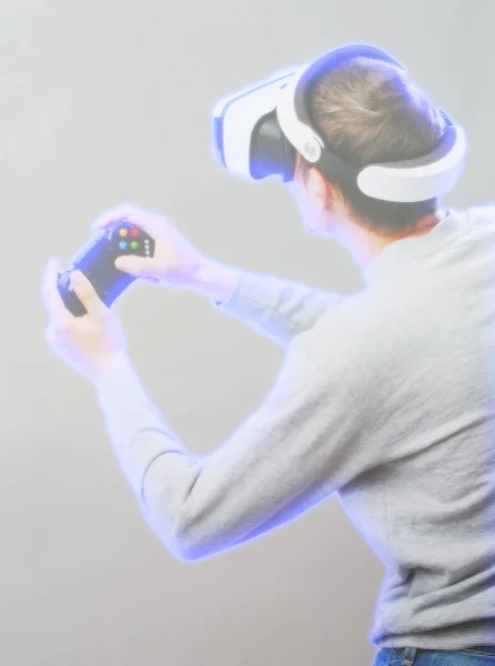 Homem com fone de ouvido realidade virtual está jogando jogo. Imagem com efeito holográfico . — Fotografia de Stock