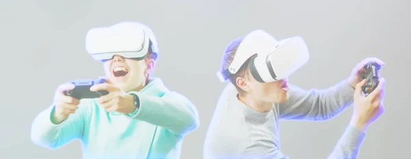 Man en vrouw met Virtual Reality headset spelen spel. Afbeelding met hologram effect. — Stockfoto