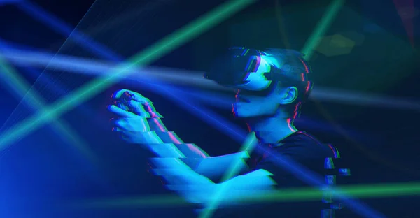 Hombre con auriculares de realidad virtual está jugando juego. Imagen con efecto glitch . —  Fotos de Stock
