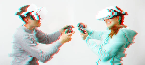 Man och kvinna med virtuell verklighet headset spelar spel. Bild med glitch effekt. — Stockfoto