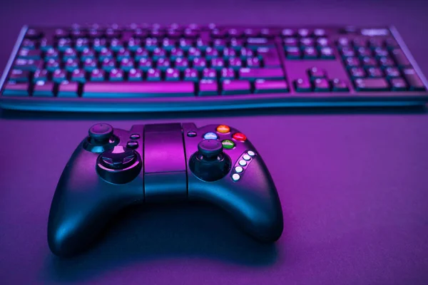 Tangentbord och joystick på violett bordsbakgrund. — Stockfoto