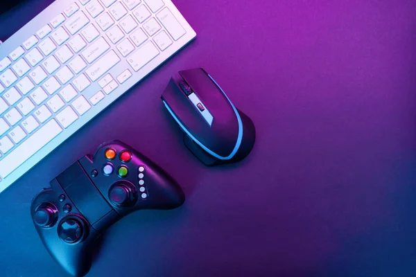 Tangentbord, mus och joystick på violett bordsbakgrund. — Stockfoto