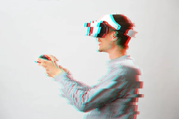 Homem com fone de ouvido realidade virtual está jogando jogo. Imagem com efeito de falha . — Fotografia de Stock