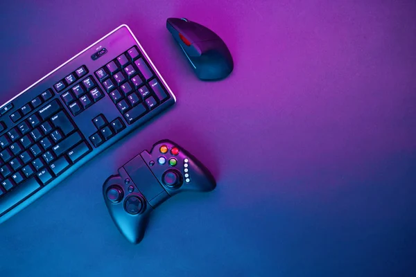 Teclado, mouse e joystick sobre fundo mesa violeta . — Fotografia de Stock