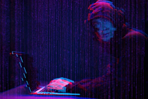 Hacker trabalhando com laptop em quarto escuro com interface digital ao redor. Imagem com efeito de falha . — Fotografia de Stock