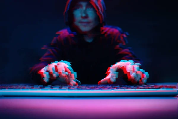 Hacker in the hood working with computer typing text in dark room. Image with glitch effect — Stock Photo, Image