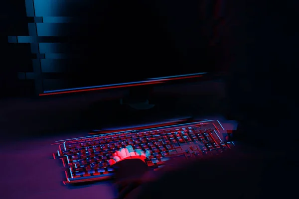Ο χάκερ στην κουκούλα δουλεύει με το κείμενο του υπολογιστή στο σκοτεινό δωμάτιο. Εικόνα με εφέ δυσλειτουργίας — Φωτογραφία Αρχείου