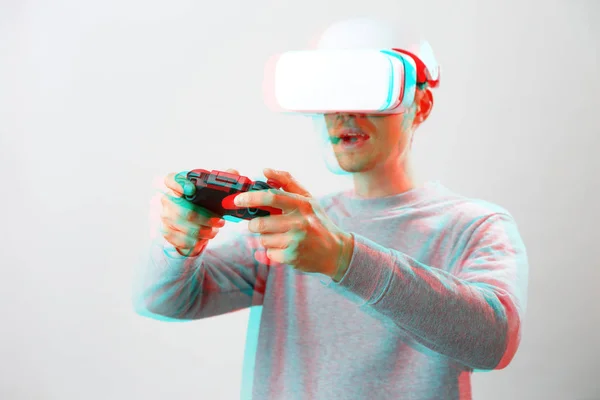 Muž se sluchátky virtuální reality hraje hru. Obrázek s efektem závady. — Stock fotografie