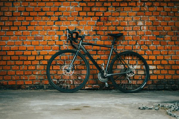 Cidade bicicleta stading novainist o fundo da parede de tijolo vermelho . — Fotografia de Stock